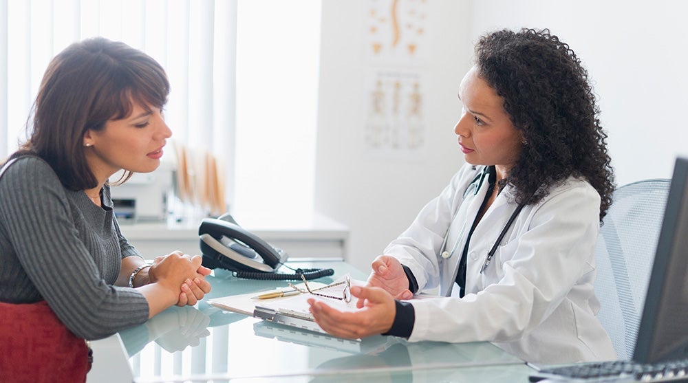 Young woman talking to her doctor