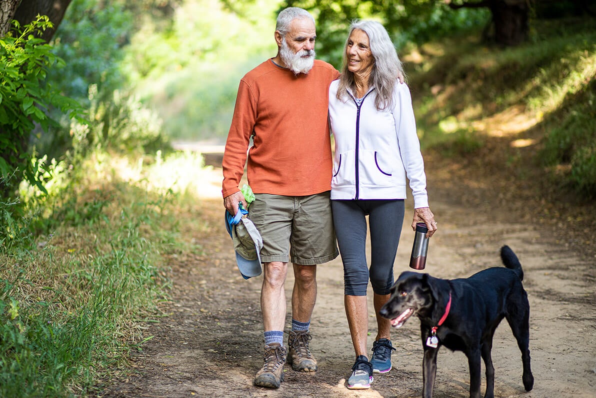 Senior couple on a hike with their dog.
