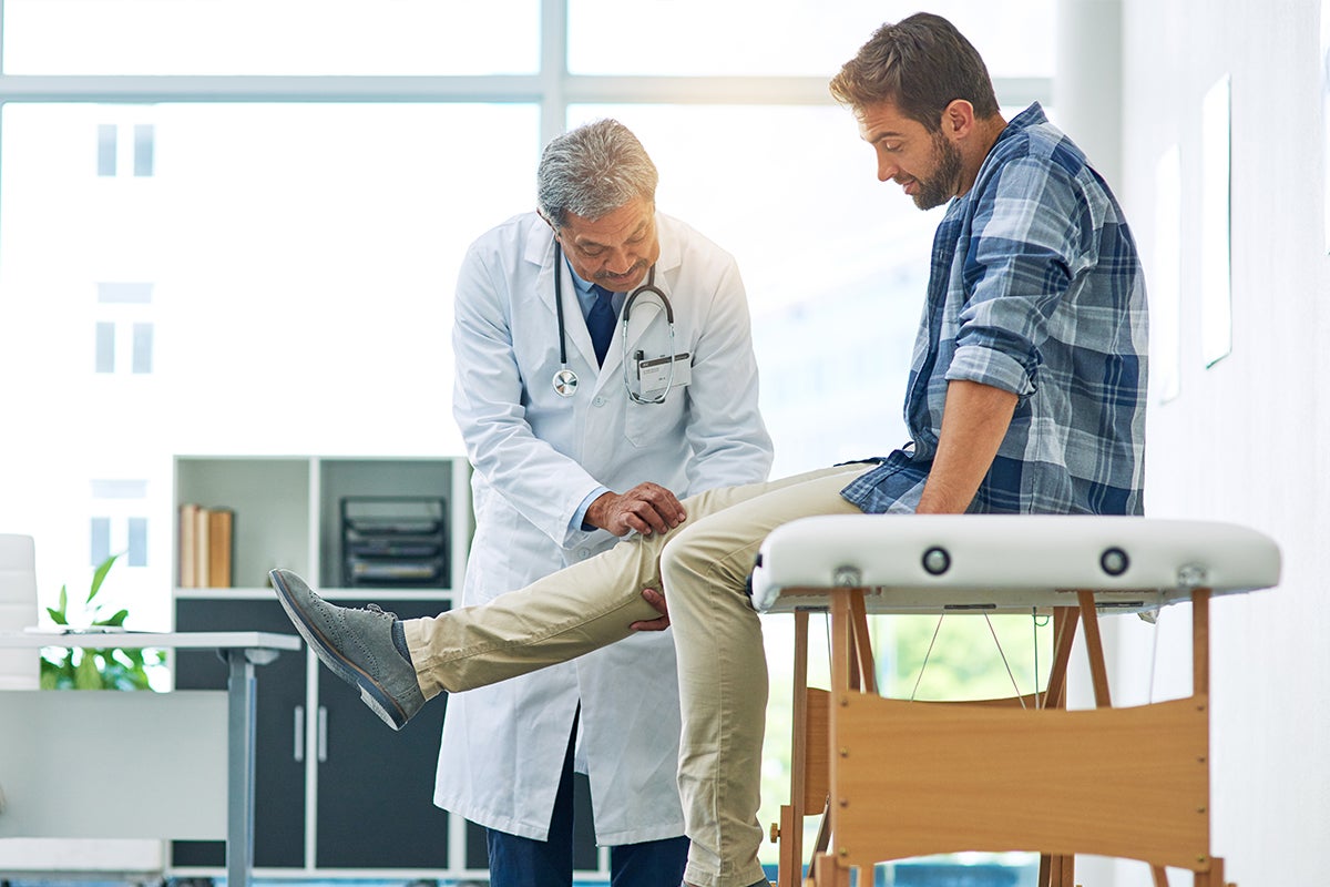 A patient having their knee examined at an orthopedic appointment